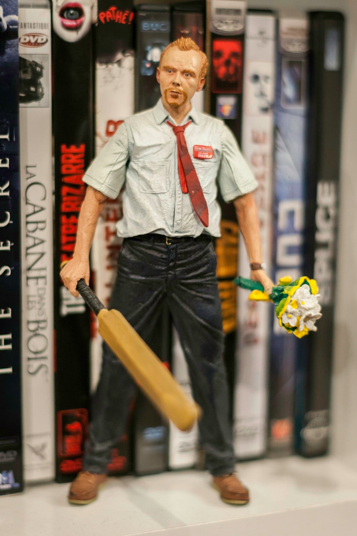 man holding baseball bat and flower figurine