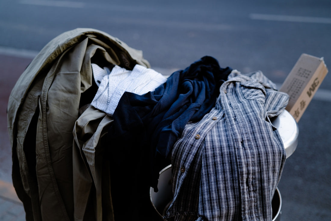 a pile of clothes sitting on the side of a road