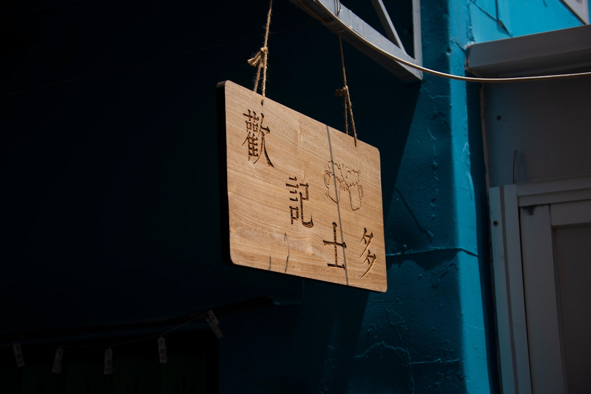 a wooden sign hanging from the side of a building