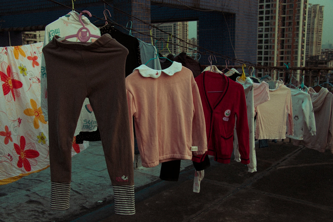 clothes hanging on a clothes line with buildings in the background