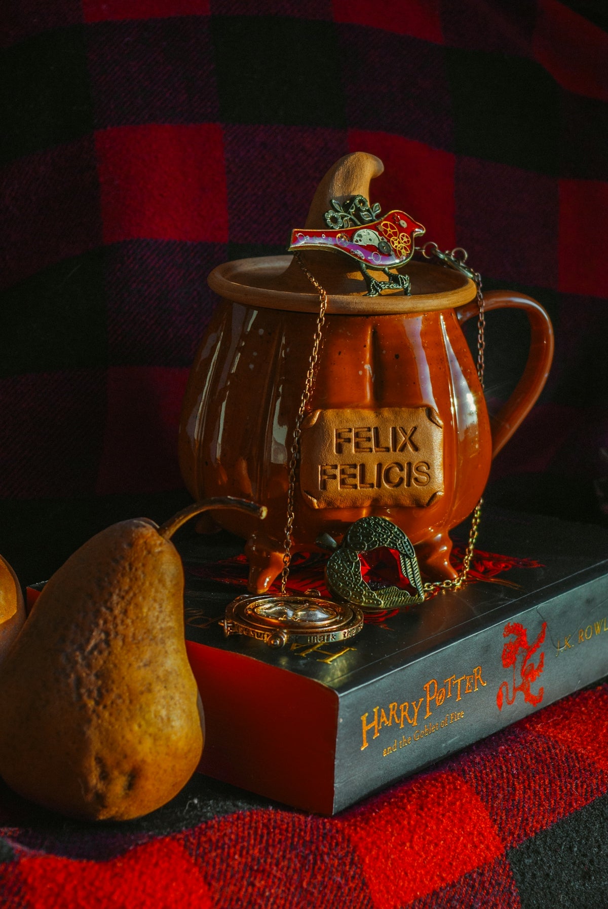 a figurine sitting on top of a book next to a pear
