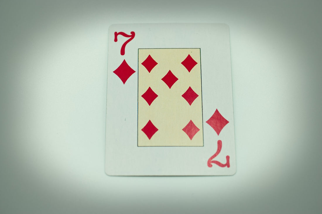 a red and white playing card on a white surface