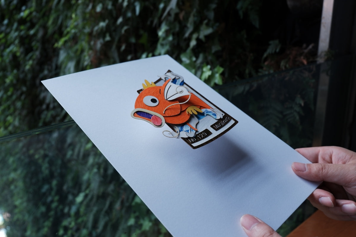 a hand holding a piece of paper with a picture of a fish on it