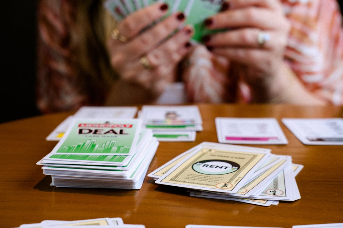 A woman sitting at a table holding a green card