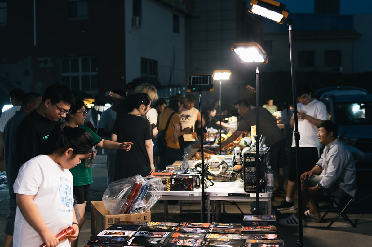 A group of people standing around a table filled with books
