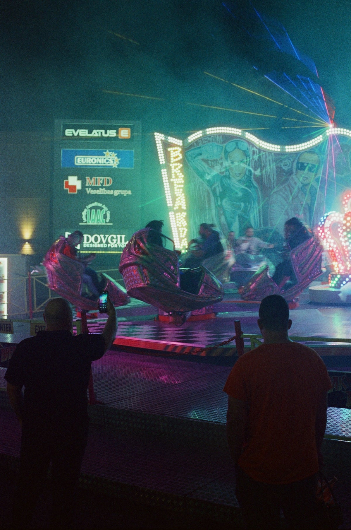 A group of people standing around a carnival ride