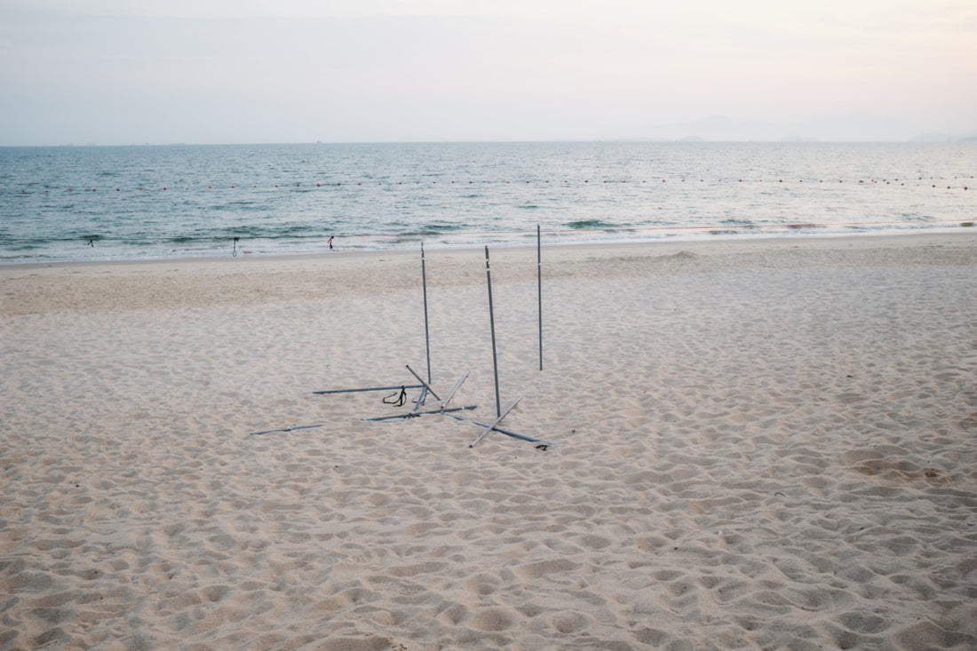 A couple of poles sitting on top of a sandy beach