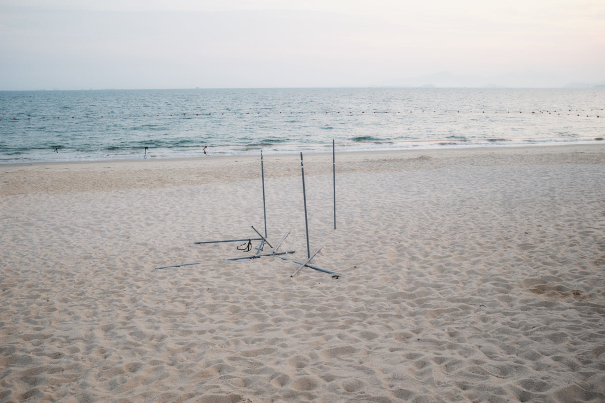 A couple of poles sitting on top of a sandy beach