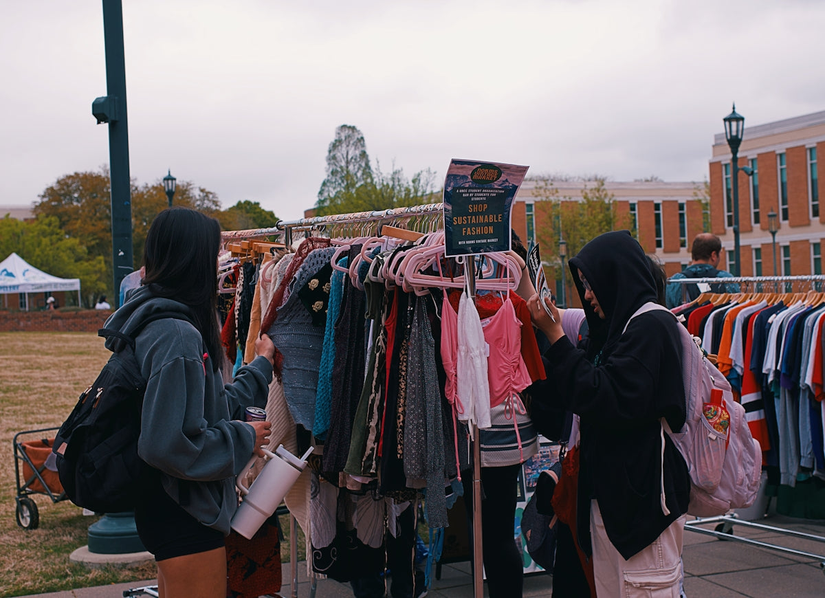People browse clothes at an outdoor pop-up shop.