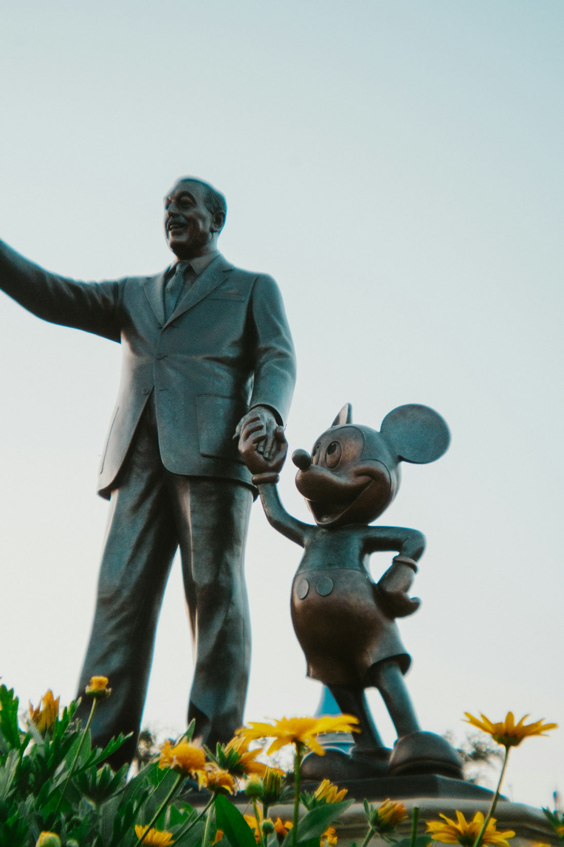 Walt disney and mickey mouse statue stand tall.