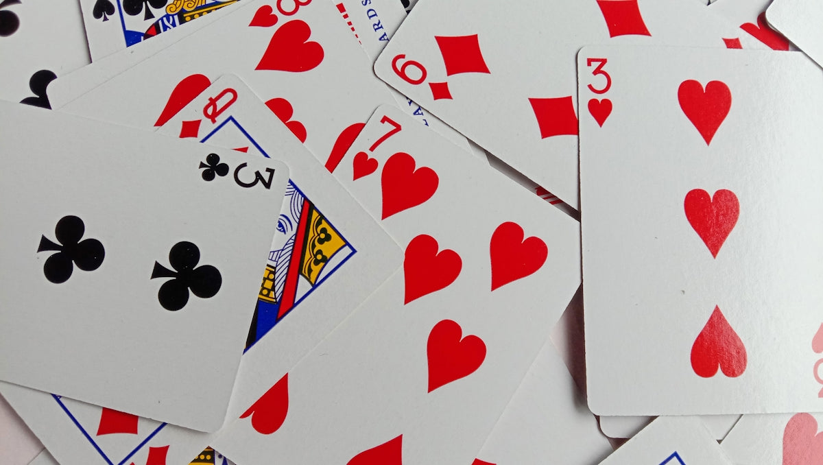 Playing cards are scattered on a surface.