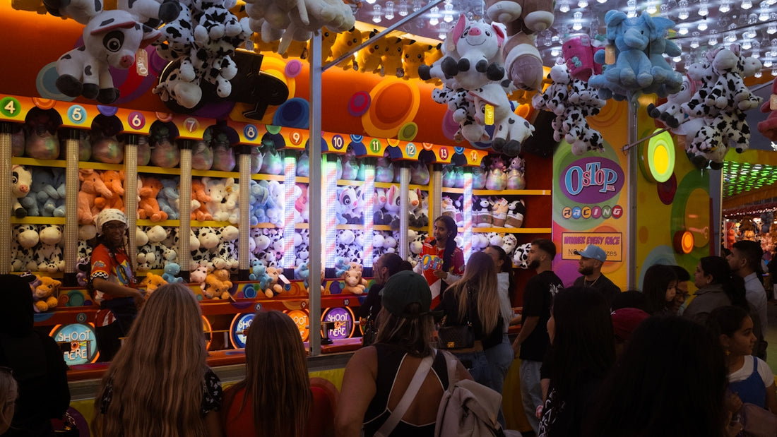 People at a brightly lit carnival game booth