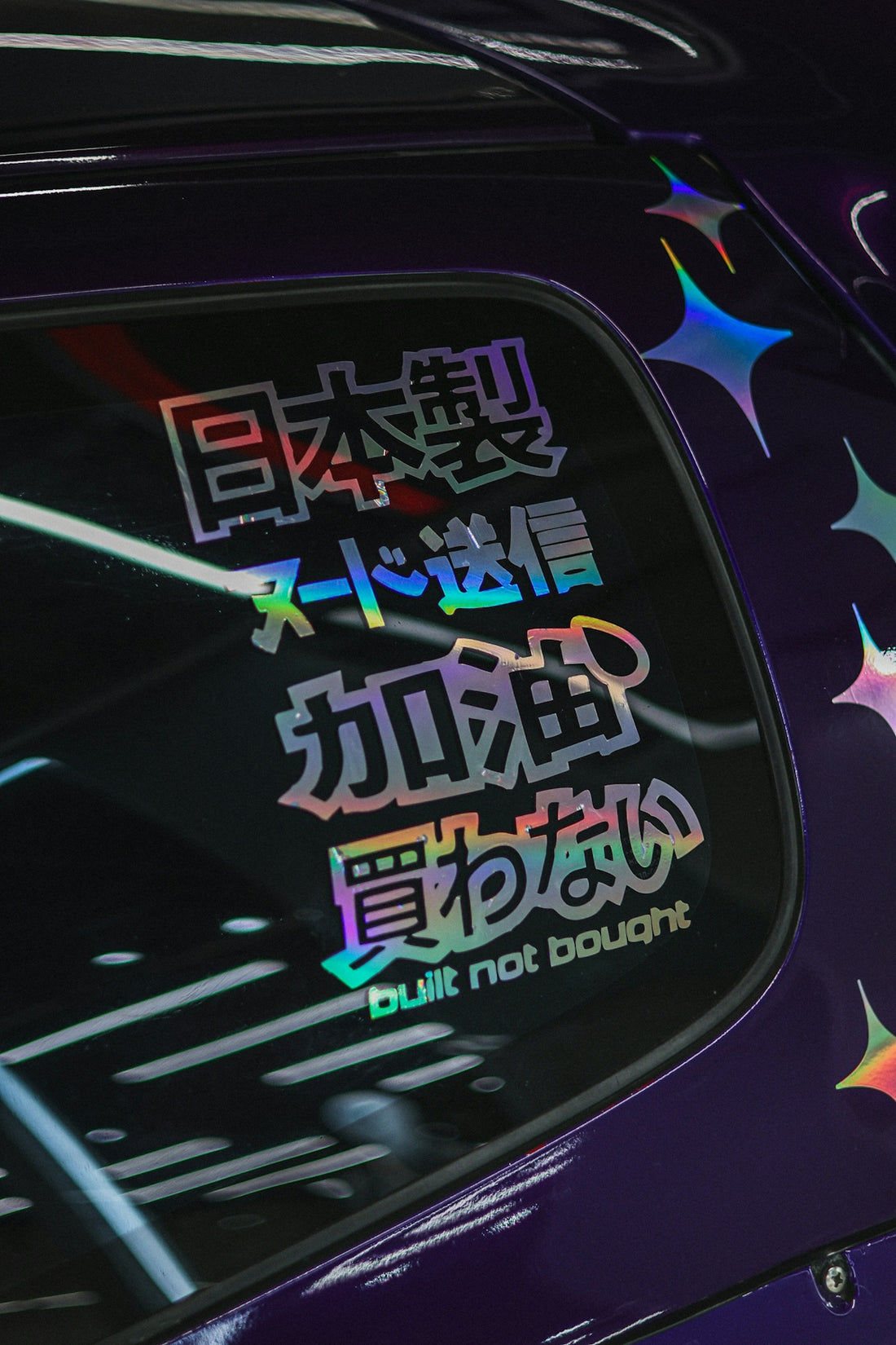 Japanese text and stars sticker on purple car window