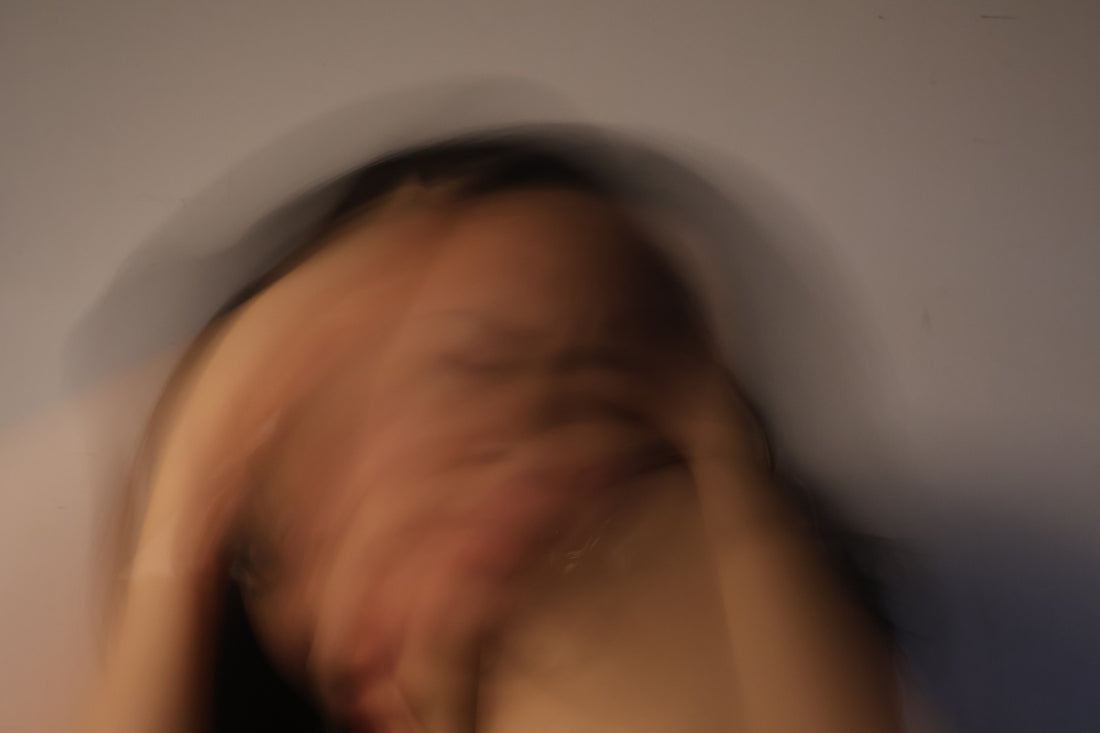Person covering face with hands, blurred motion.